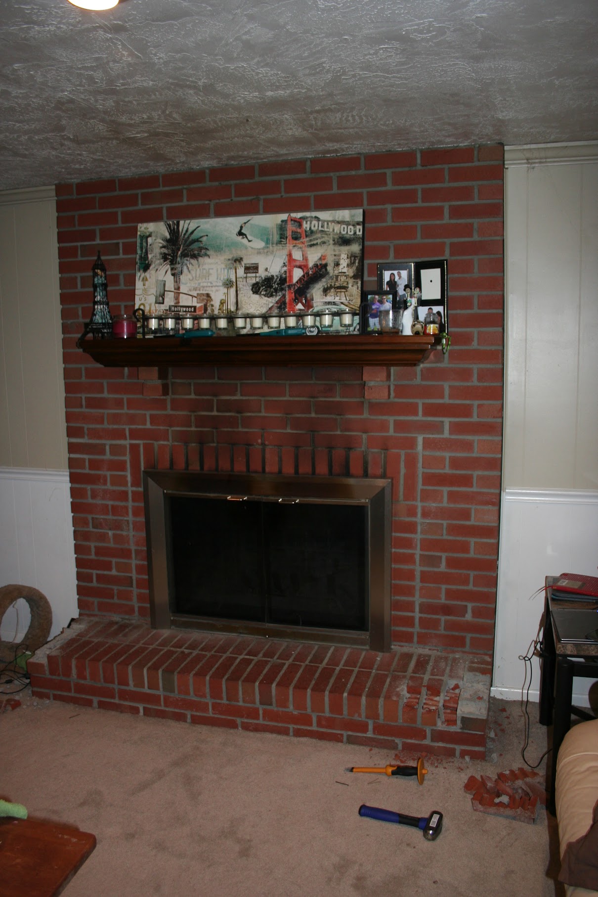 Brick fireplace with hearth intact and tools on floor