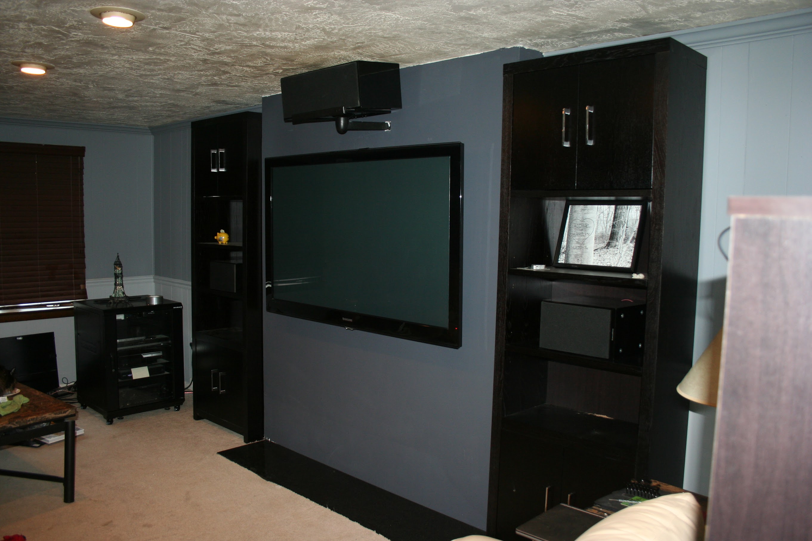 Wider angle of TV wall with speaker on top